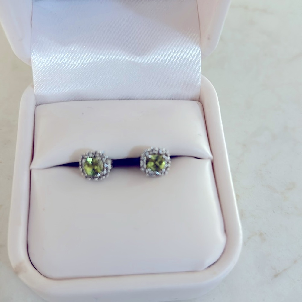 Peridot stud earrings surrounded by small diamonds set in sterling silver